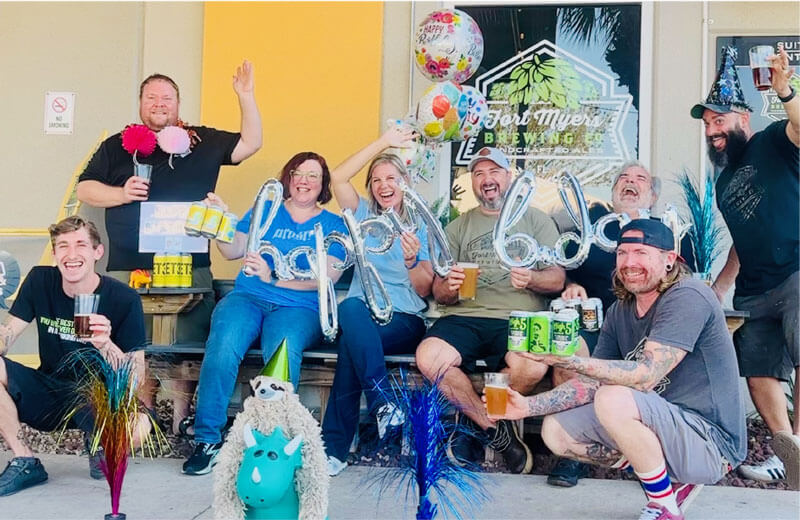 A group of people posing for a photo with balloons.