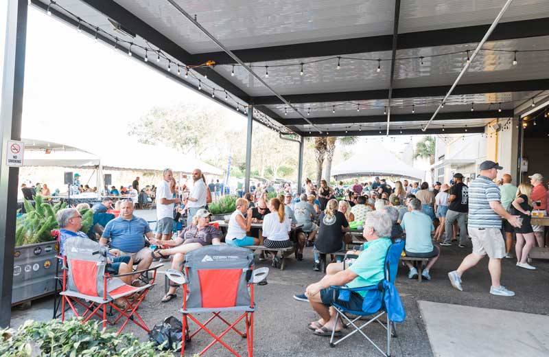 A crowd of people sitting on lawn chairs at an outdoor event.